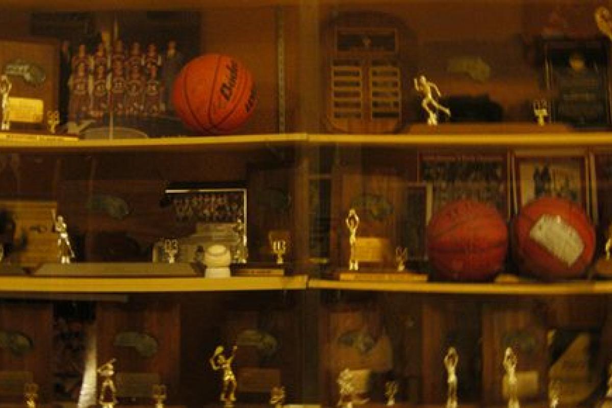 An extensive collection of basketball trophies and team photographs exemplifying our inductees' athletic accomplishments.